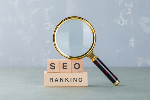 Magnifying glass over blocks showing “SEO Ranking,” symbolizing security’s impact on SEO.