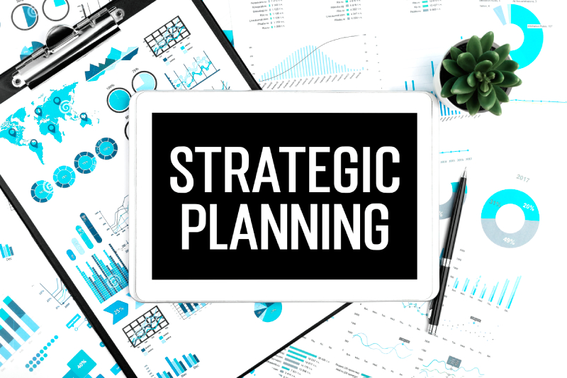 Tablet with 'Strategic Planning' amid charts symbolizing data-driven business goals.
